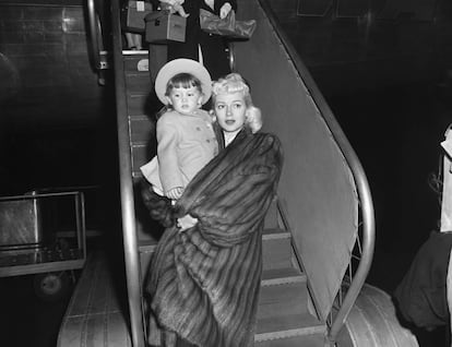 Lana Turner bajando de un avión con su hija Cheryl en brazos en Nueva York en 1946.