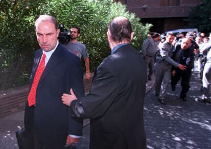 Arturo Codina (izquierda), abogado de Eurobank en la suspensión, increpado a la salida de la junta, ayer.
