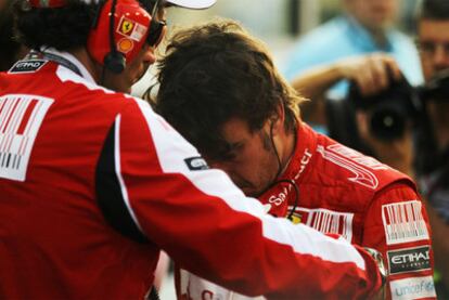 Fernando Alonso, junto a uno de los técnicos de Ferrari.