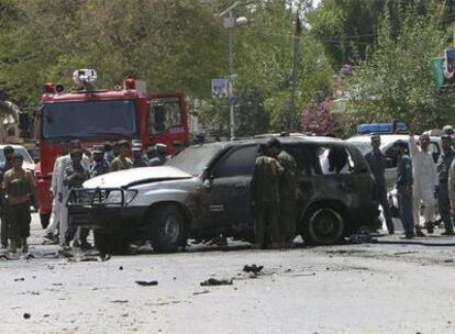 Varios transeúntes observan la escena del atentado con coche bomba que mató al número dos del espionaje afgano y a otras 22 personas en el municipio de Mehtar Lam.