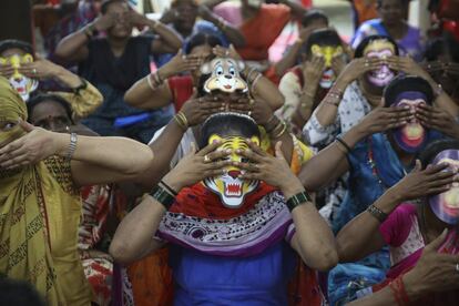 Trabajadoras sexuales con máscaras de animales practican yoga en la víspera del Día Internacional del Yoga, en Bombai, India.