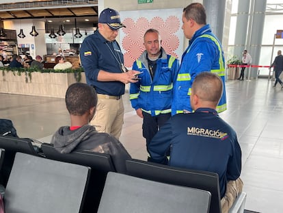 Agentes migratorios hablan con un menor guineano, en el Aeropuerto El Dorado, en Bogotá, el pasado 19 de diciembre.