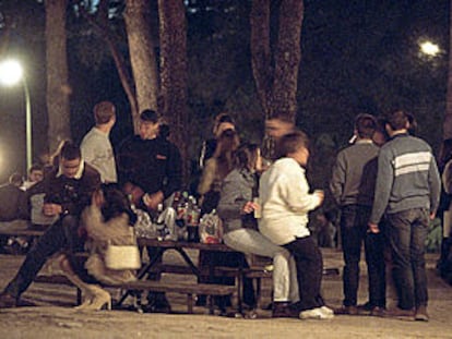 Jóvenes consumiendo alcohol durante un <b></b><i>botellón</i> en un parque de Madrid.