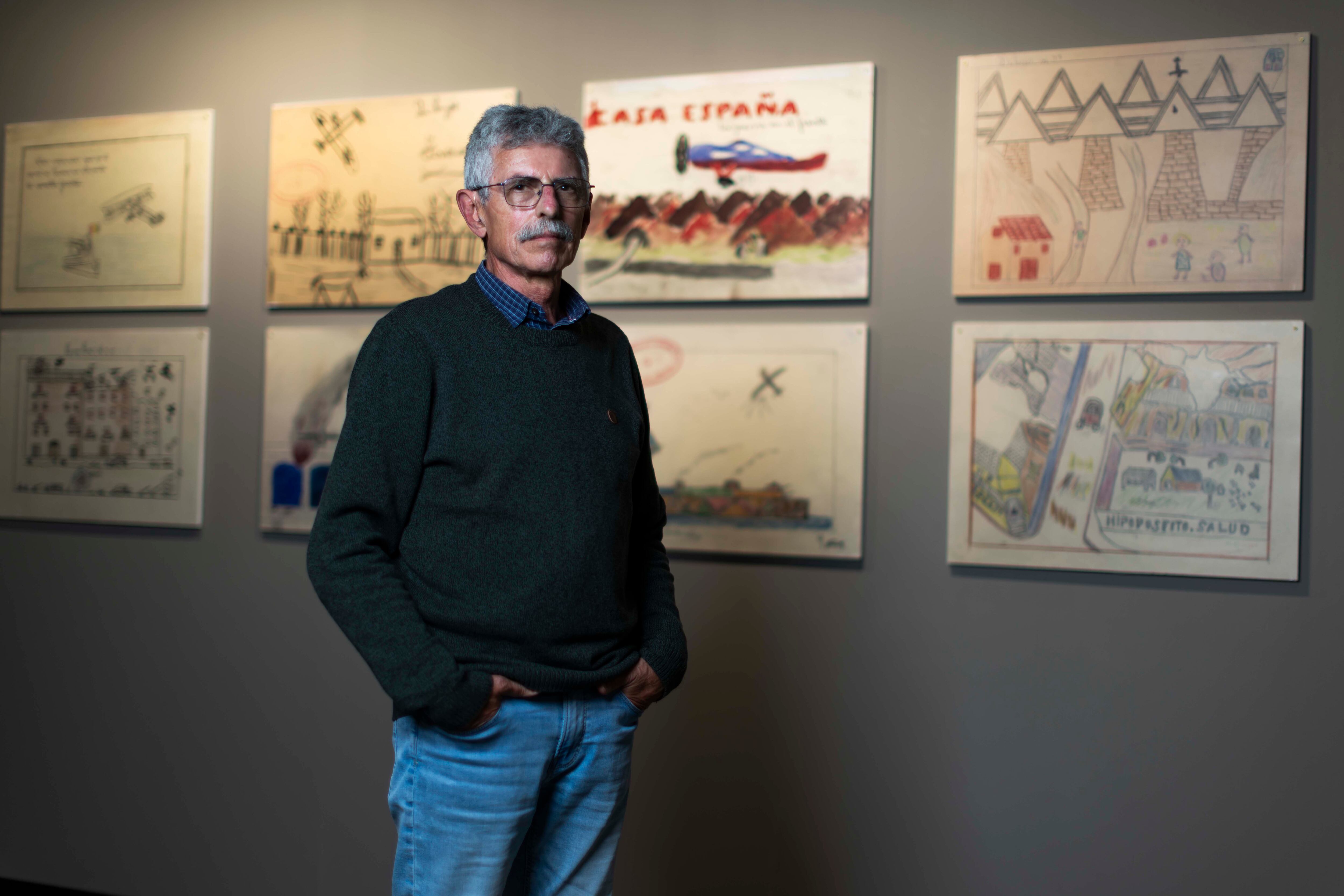 Vladimir Merino, comisario de la exposición, delante de algunos de los dibujos.