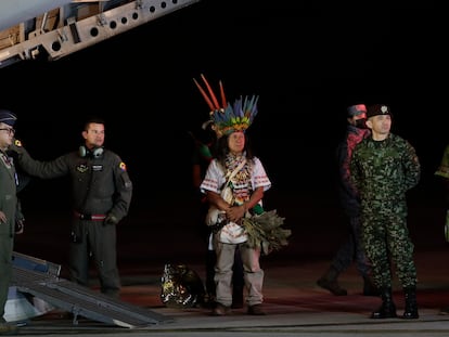 Military personnel and Indigenous leaders stand under a plane after the arrival of four siblings found after 40 days in the jungle.