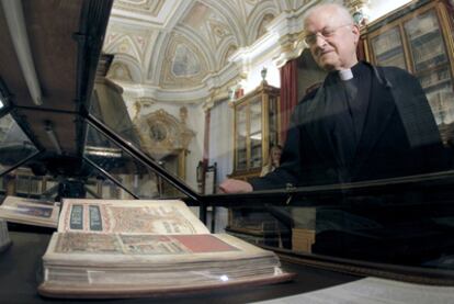 El deán José María Díaz observa una edición facsímil del Códice Calixtino, expuesta en una sala de la catedral de Santiago, de cuyo archivo ha desaparecido la obra original