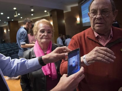 Un Mosso d'Esquadra escaneja amb el seu mòbil el codi QR de la polsera per identificar a malalts d'Alzheimer en cas que es perdin.