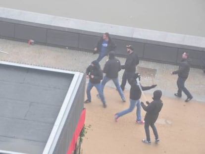 Uno de los menores detenidos, con capucha y una barra blanca.