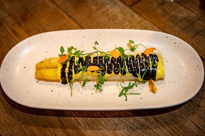 El plato de espárragos blancos a la brasa con salsa de azafrán y tinta de calamar del restaurante La Mundana en el barrio de Sants de Barcelona.