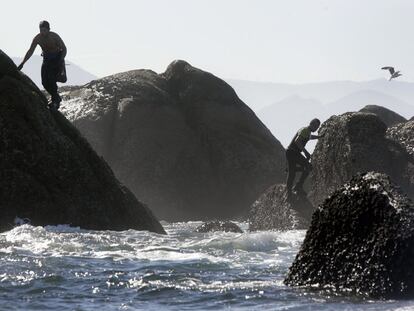Dos <i>percebeiros</i> mientras faenan en las rocas de Lira, en la Costa da Morte.