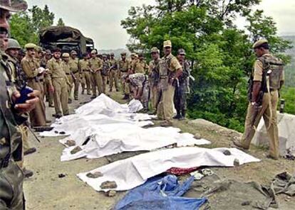 Militares y policías indios, ante los cuerpos de los soldados y sus familiares muertos en un