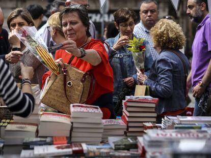 Una dona comprant en una parada de llibres de la Rambla per Sant Jordi.