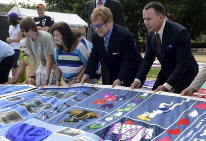 Elton John, su pareja David Furnish y Jeanne White-Ginder, madre de Ryan White, amigo del artista que perdi&oacute; su batalla contra el SIDA en 1990, visitan el SIDA Memorial Quilt, en Washington, Estados Unidos.