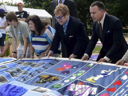 Elton John, su pareja David Furnish y Jeanne White-Ginder, madre de Ryan White, amigo del artista que perdi&oacute; su batalla contra el SIDA en 1990, visitan el SIDA Memorial Quilt, en Washington, Estados Unidos.