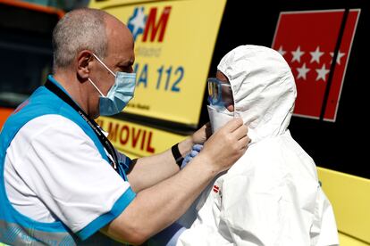 Trabajadores sanitarios participan en la desinfección de dos autobuses de la autoescuela Lara cedidos para el traslado de pacientes de covid-19 entre hospitales de la Comunidad de Madrid.