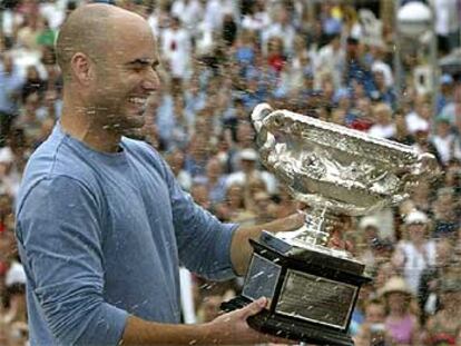 Agassi es regado con cava tras recibir el trofeo que le acredita como ganador en Australia.