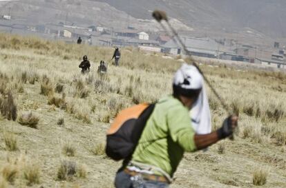 A protestor slings a rock at police at the Tintaya mine.