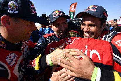 Los pilotos Stéphane Peterhansel (Mini) y Al Attiyah (Toyota), segundo y tercero en la clasificación, abrazan a Carlos Sainz tras proclamarse campeón del Dakar 2020 este viernes.