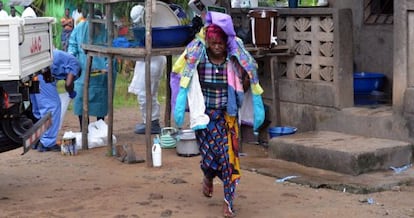 Un mujer carga objetos de su esposo, fallecido por el &eacute;bola, en Liberia. 