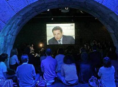 Un grupo de personas sigue el debate, a través de una pantalla gigante, en un club de París.