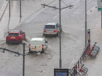 Unos coches circulan con dificultad tras la tormenta que ha caído este jueves en Zaragoza.