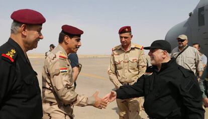 El primer ministre iraquià, Haider al-Abadi, saluda oficials de la policia i l'exèrcit aquest diumenge a la seva arribada a Mossul.