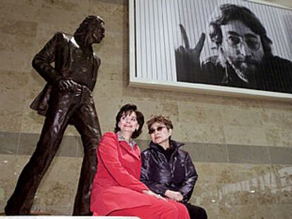 Yoko Ono y Cherie Booth (esposa de Tony Blair) sentadas al pie de una estatua en bronce de John Lennon.