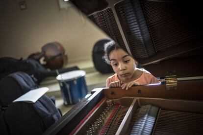 Una de las alumnas más jóvenes de la escuela mira con curiosidad el interior de uno de los pianos al finalizar la clase de solfeo.