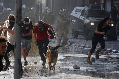 Manifestantes antigubernamentales chocan con la policía mientras protestan contra el aumento del coste de vida el 20 de octubre de 2019 en Santiago, Chile. Las protestas comenzaron el viernes y se convirtieron en saqueos e incendios provocados, generando caos en Santiago, Valparaíso y una docena de otras ciudades chilenas.