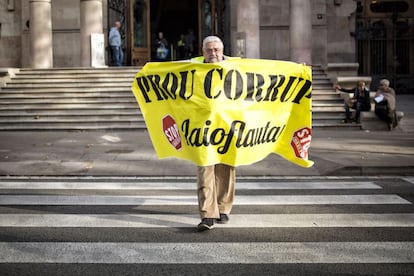 IÑIGO DOMÍNGUEZ / CARLES RIBAS - Este señor de Barcelona es un yayoflauta confeso y sostiene una pancarta que dice, en catalán, “Basta corrupción”. Estaba este jueves en una manifestación de apoyo a jueces y funcionarios de los tribunales ante "las presiones políticas". Probablemente tiene otras cosas que hacer, pero hizo esa. Emerge como un superhéroe amarillo de un fondo gris y rayado. El cabreo acumulado en la calle se ha ido amortiguando; desde 2011 ha pasado de noticia a sobreentendido, pero sigue latente y decidirá indecisos. La imagen recuerda que la indignación no era solo cosa de chavales y que si los yayoflautas, siendo la tercera edad del 15-M, no se han cansado, quizá a los demás tampoco se les haya pasado.