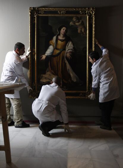 Operarios colocaban ayer el cuadro <b><i>Santa Catalina de Alejandría, mártir</b></i> en el Bellas Artes de Sevilla.