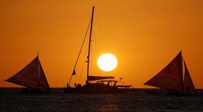 Turistas navegan en veleros durante el atardecer en Boracay (Filipinas).