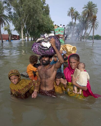 Una familia intenta avanzar por el agua en la provincia de Punjab.