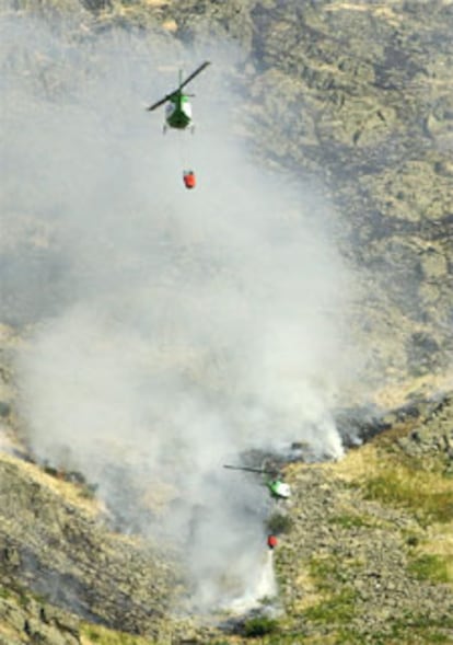 Dos helicópteros operan en las labores de extinción del incendio en Bustarviejo.