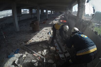 Dos 'cascos blancos' recuperan el cuerpo de Yahya al Judur, de 20 años, tras el bombardeo contra una granja de Maarrat Misrin, en Siria, el día 11. Imagen cedida por Syria Civil Defense.