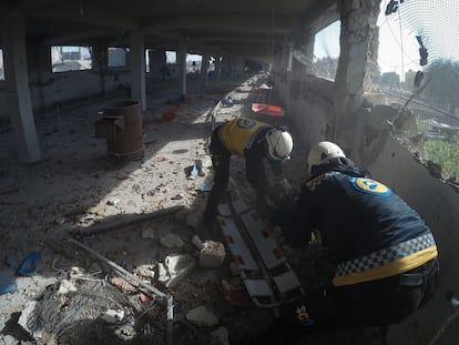 Dos 'cascos blancos' recuperan el cuerpo de Yahya al Judur, de 20 años, tras el bombardeo contra una granja de Maarrat Misrin, en Siria, el día 11. Imagen cedida por Syria Civil Defense.