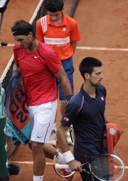 Nadal se cruza con Djokovic durante el partido.