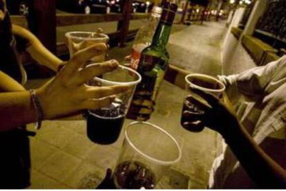 Joves consumeixen alcohol al carrer. 