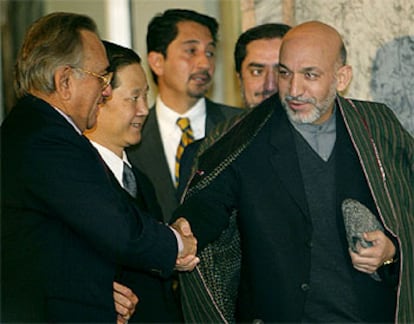 El presidente afgano, Hamid Karzai, estrecha la mano al ministro de Exteriores de Pakistán, Mian Khurseed.