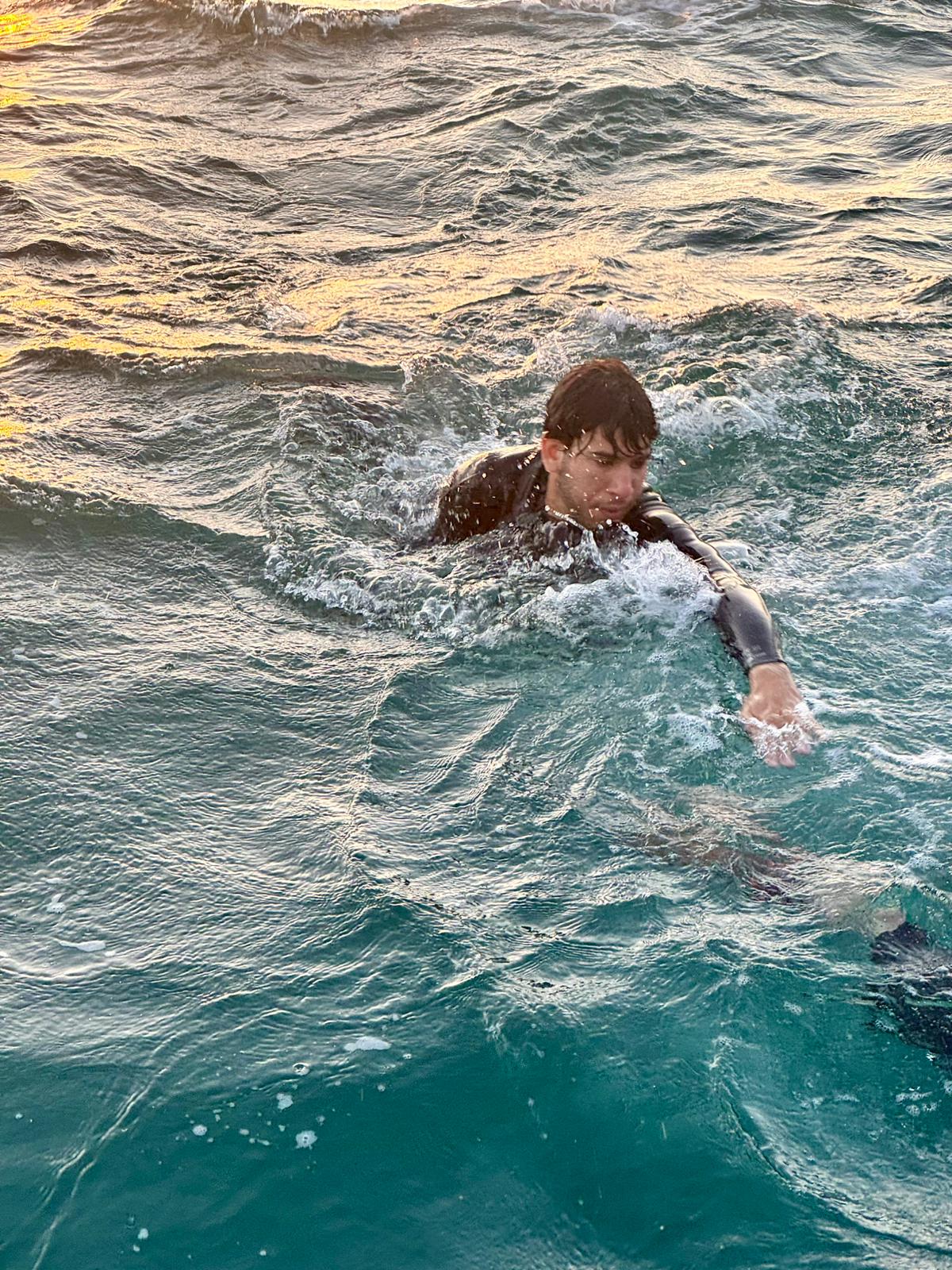Un joven intenta llegar a nado a Ceuta desde Marruecos, este sábado, en una imagen cedida. 