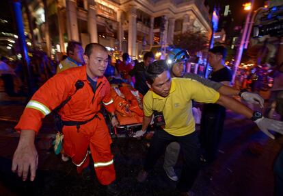 Miembros del personal de emergencias trasladan a un herido tras un atentado en el centro de Bangkok (Tailandia). Al menos 16 personas han muerto, entre ellas cuatro extranjeros, en la explosión de una moto bomba junto a un templo budista en Bangkok.