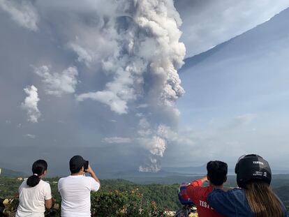 Miles de turistas visitan cada año el Taal y algunos realizan excursiones hasta su cráter, parcialmente inundado y en el que es fácil ver pequeñas fumarolas. En la imagen, varias personas fotografían la columna de ceniza del volcán Taal, desde Tagaytay.