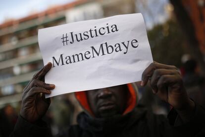 Un hombre sostiene un cartel con la leyenda "Justicia MameMbaye".