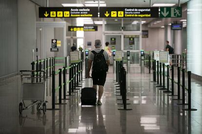 El eeropuerto de Barcelona pone nuevamente en servicio la T2 para adaptarse a la situación operativa y facilitar la distancia de seguridad y evitar posibles aglomeraciones ante el coronavirus. En la imagen, un viajero en la Terminal 2, este sábado.