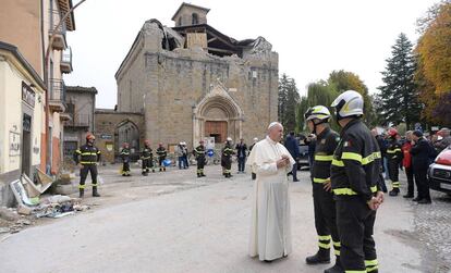 El Papa conversa con unos bomberos, este martes frente a una iglesia destruida por el terremoto en Amatrice (Italia).