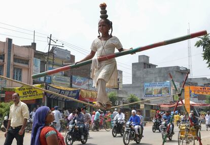 Una niña india realiza ejercicios de equilibrio sobre una cuerda durante un espectáculo en una calle de Batala (India).