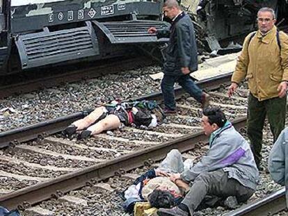 Algunas víctimas recorren las vías de la estación de Atocha momentos después el atentado, mientras otras yacen en el suelo.