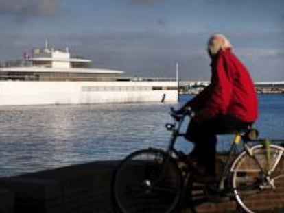 Un hombre que pedalea en su bicicleta observa como el yate ordenado construir por el cofundador de Apple Steve Jobs, compite en una regata cerca de Velsen, Holanda. EFE/Archivo