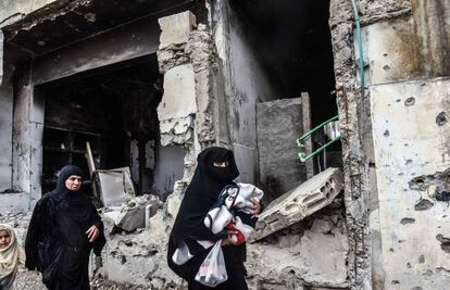 Várias mulheres caminham pela cidade de Raqa.