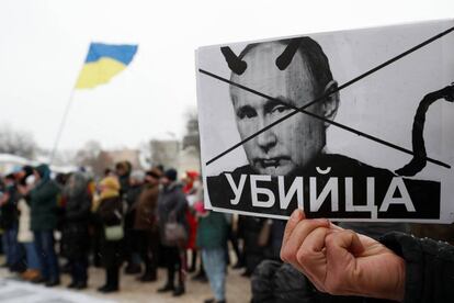 Un manifestante ucraniano sostiene una pancarta con el rostro de Vladimir Putin